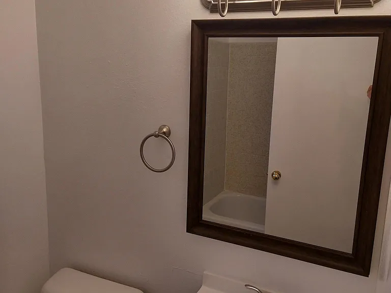 Newly refurbished bathroom, vanity, tub / shower, window blinds, and tile flooring for easy cleaning,