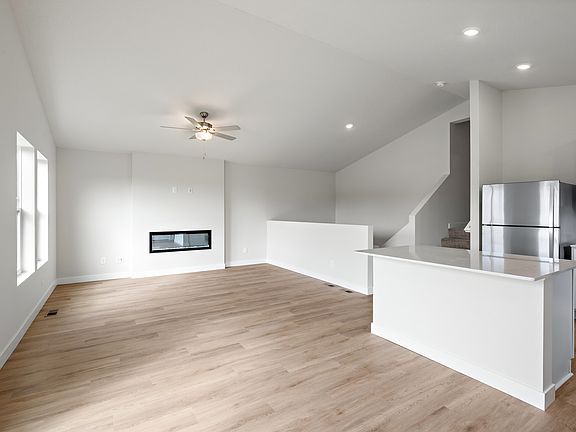 The family room is spacious with a ceiling fan and fireplace.