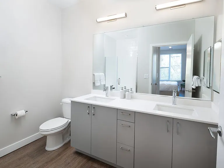 Modern baths with light grey cabinetry, white quartz countertop, and hard surface flooring