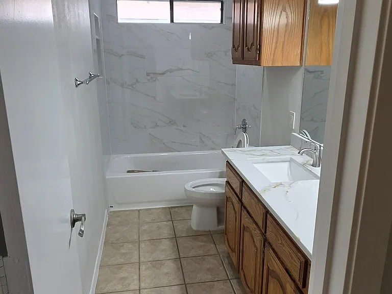 guest bathroom features new tub and tile, new quartz counter with lots of space of bathroom essentials