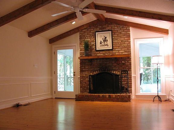 Open living room has wood burning fireplace, new flooring & paint.