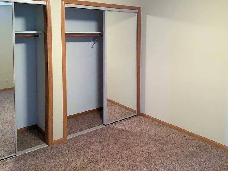 Unwind in your comfortable bedroom with a mirrored closet that helps the space feel larger while keeping your wardrobe organized.