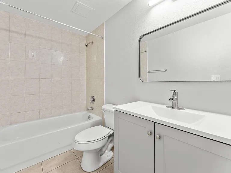 Elegant bathroom featuring a modern vanity, spacious bathtub, and stylish tile design.