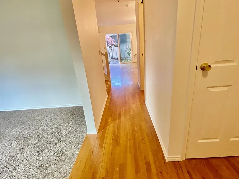 View from entrance of double-front doors. Main floor bathroom to right, living room #1 to left. Kitchen through hall.