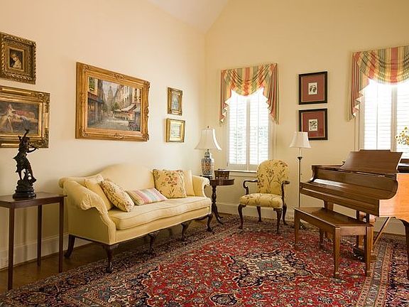 A lovely living room has French doors, hardwoods and plantation shutters.
