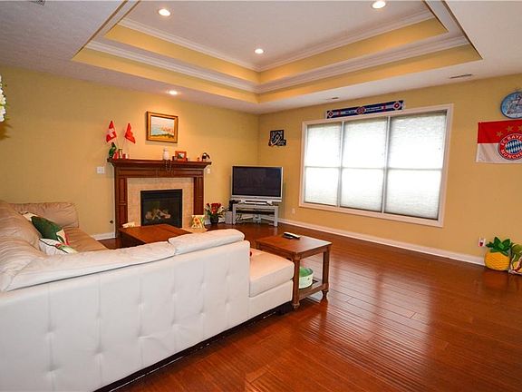 Great room features tray ceilings and lighting.   Gas fireplace and opens into breakfast room and kitchen.