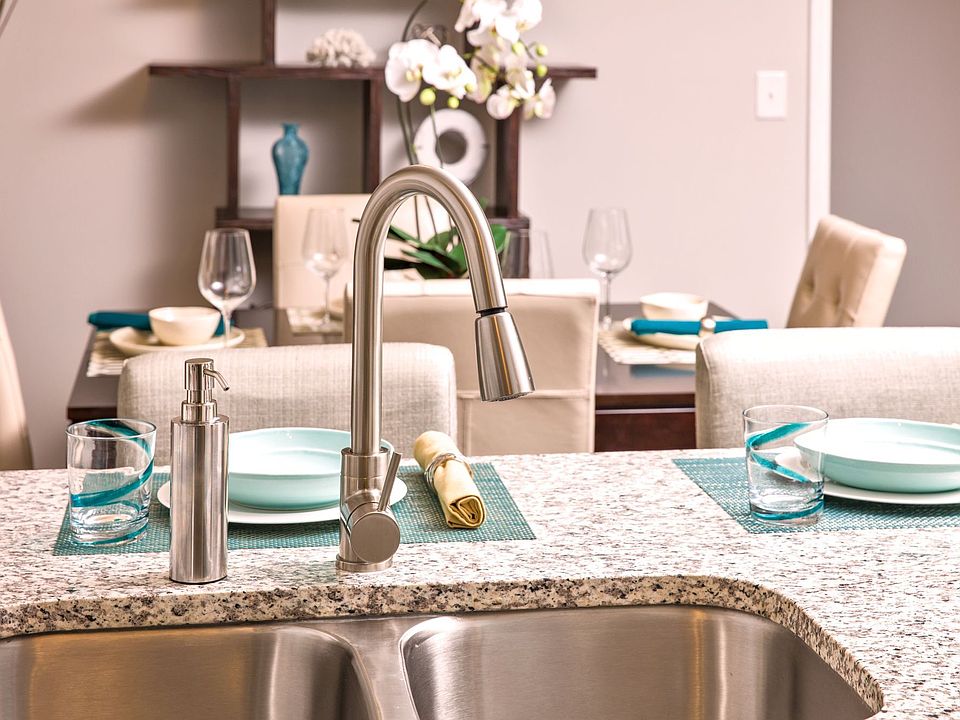 Kitchen sink with a modern faucet and granite counter tops.
