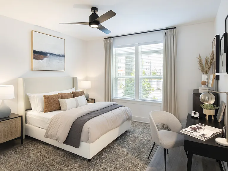 Elegant bedroom with a cozy bed, stylish decor, and abundant natural light, perfect for relaxation and comfort.