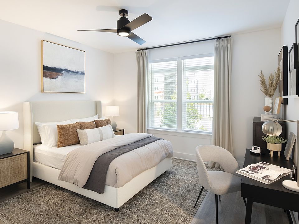 Elegant bedroom with a cozy bed, stylish decor, and abundant natural light, perfect for relaxation and comfort.