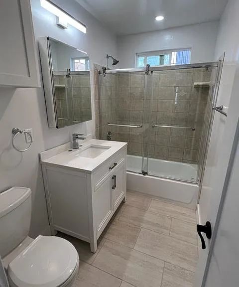 2nd full bath (hallway) with glass shower doors and large vanity and mirrored medicine cabinet