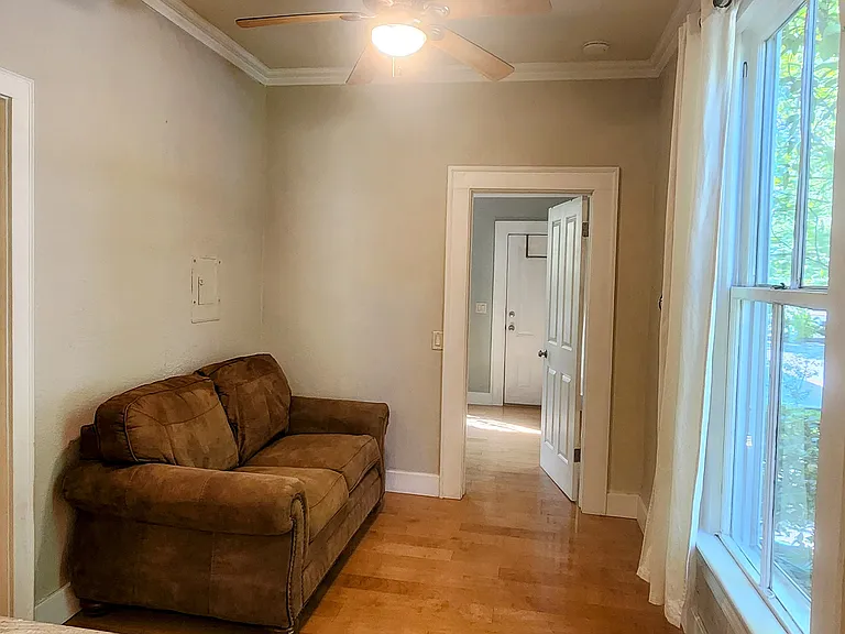 Living room, good light, comfortable couch can stay or go.
