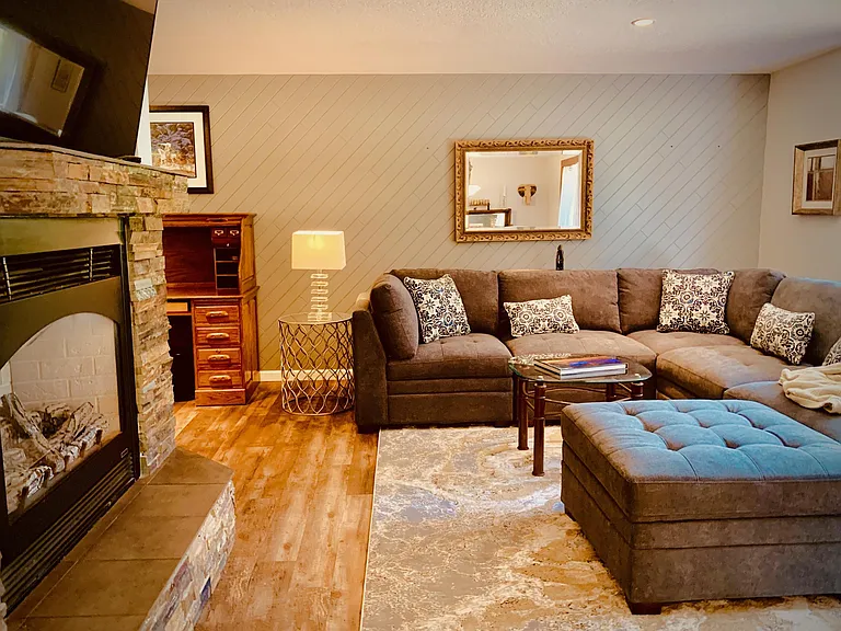 The main living room has a gas fireplace, a large smart TV on a swivel, and the most comfortable couch.
