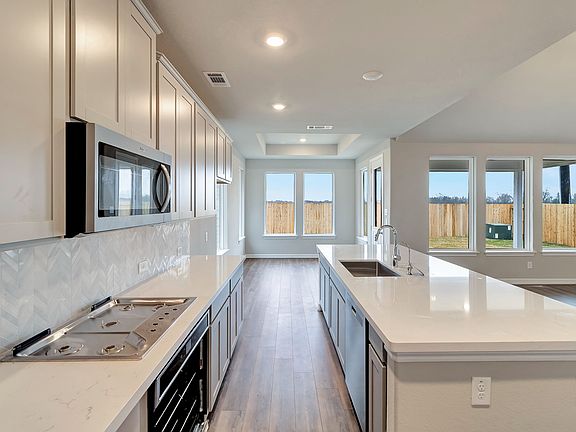 The kitchen has ample countertop and cabinetry space and open to the breakfast area