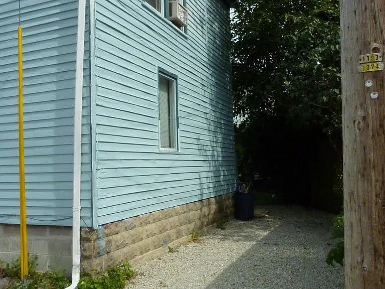Back of home, one car parking behind house