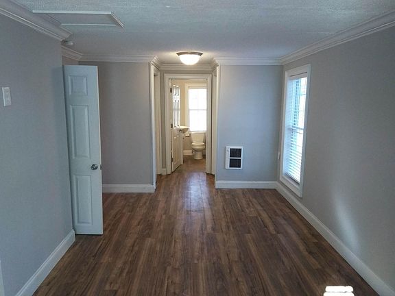 Viewed from front of bedroom into bathroom. Stackable laundry on left, closet on right. Electric heater on right.