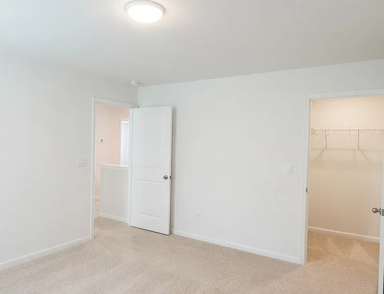 Third bedroom, another well-sized carpeted bedroom with closet access and soft lighting. Neutral finishes throughout make it easy to personalize.