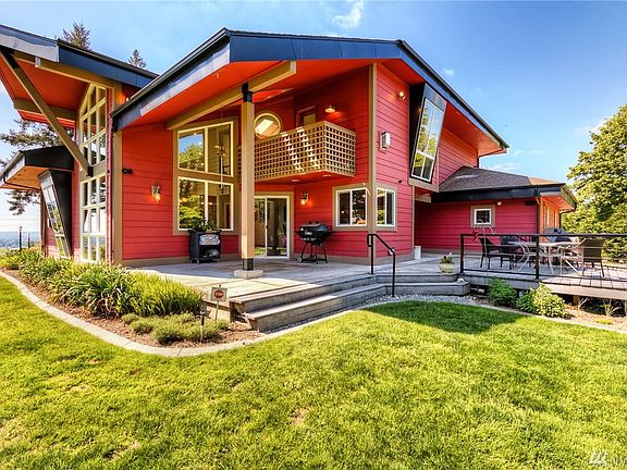 Wow look at the cool architecture. There are angled windows and floor to ceiling windows. This photo shows the upper deck off the bonus room, the covered patio perfect for barbecuing and a sunny deck.
