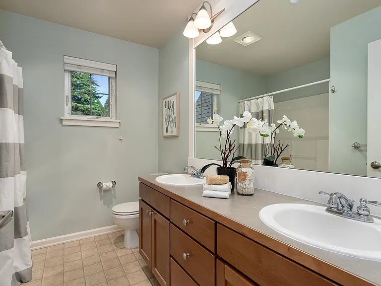Full bathroom with dual sinks.