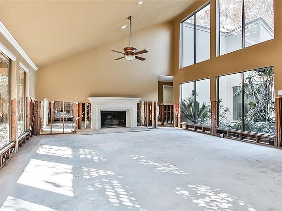 Great room with an expanse of windows overlooking an atrium with lush landscaping.