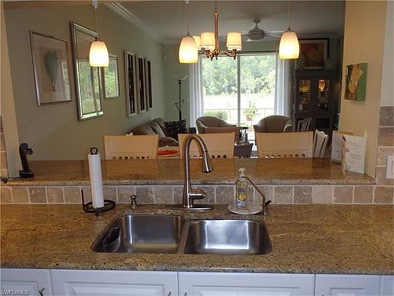Santa Cecelia granite, travertine backsplash, art glass pendants - view to lanai