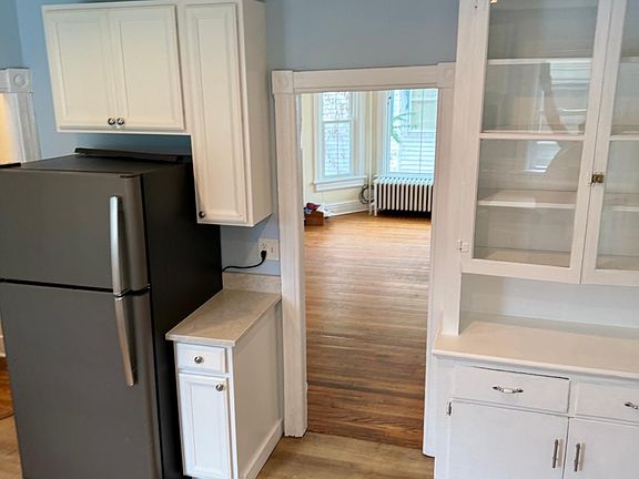 Renovated Kitchen with Quartz Counter Top, GE Refrigerator, New and Restored Cabinetry, Freshly painted with new hardware.