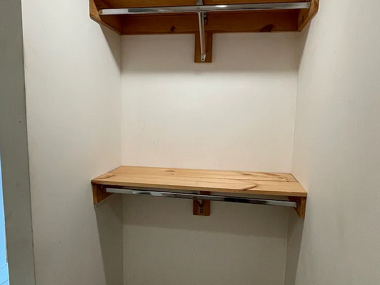 Convenient walk-in closet with built-in shelving, accessible through the primary bathroom.