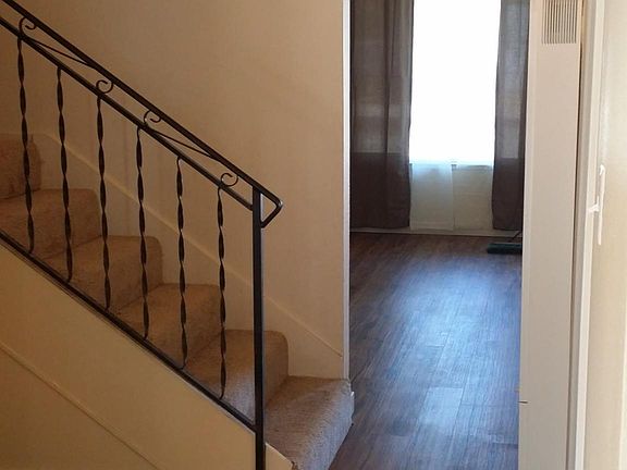 From living room towards kitchen and 1/2 bathroom. Stairs up to both bedrooms and full bathroom.