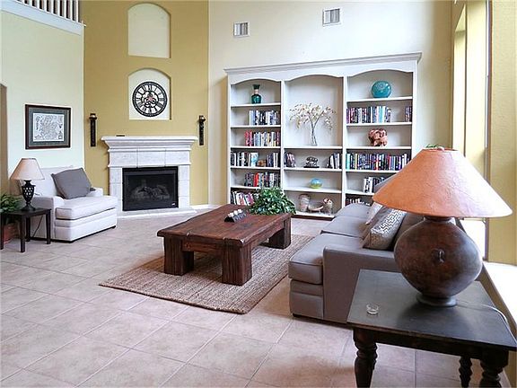 Gaslog fireplace and wall of shelving in living.