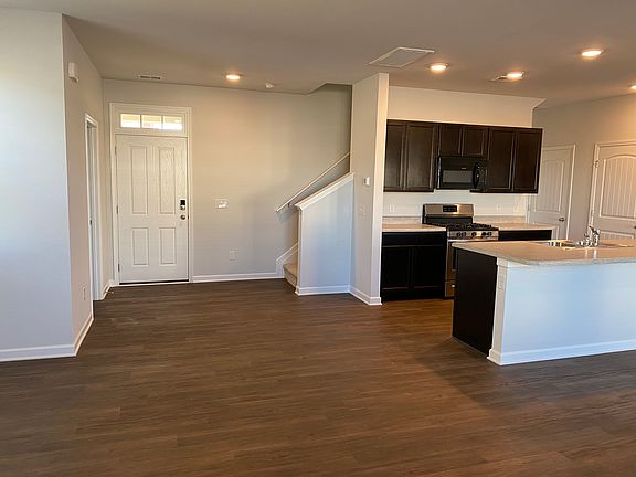 View of front entrance area, half-bath to the left, stairs to second floor to the right, kitchen to the right