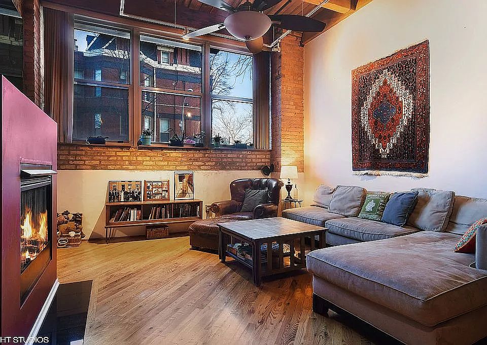 Living area with gas fireplace and over-sized windows looking out on Laflin Ave.
