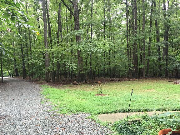 long driveway with wooded lot & trails