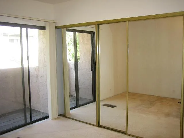 Master bedroom and mirrored closet doors across the wall