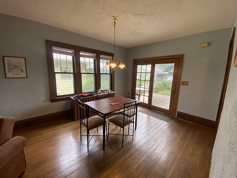 Dining room with ample natural light from large windows and a door to the back deck