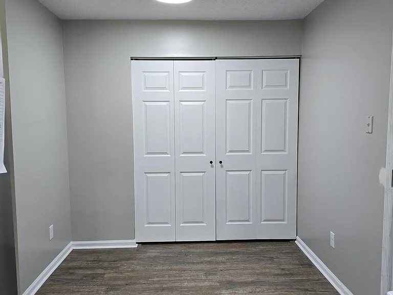 Direct view of laundry/storage closet from kitchen. Side door is to the right (just out of range of photo); flooring visible here.