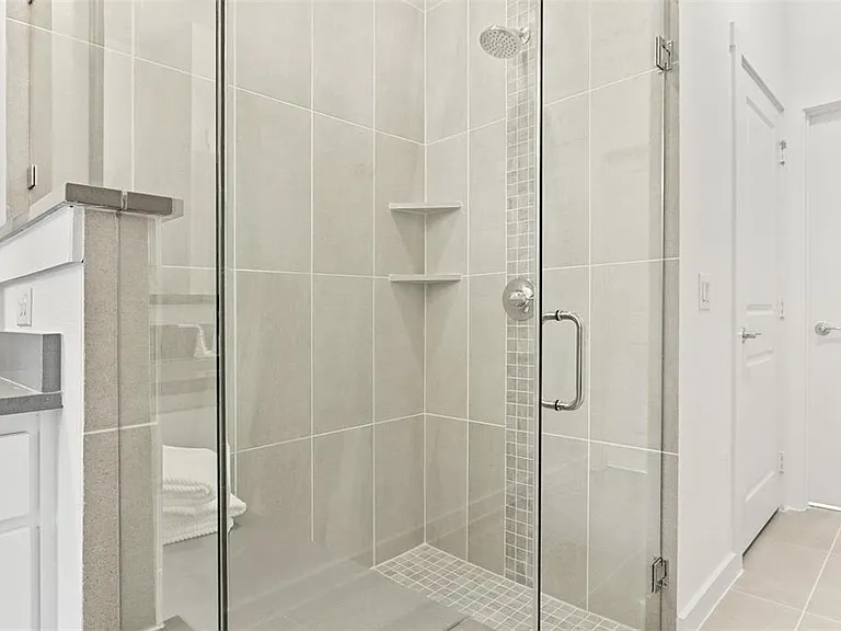 Spacious walk-in shower featuring rainfall showerhead and a bench to sit and relax.