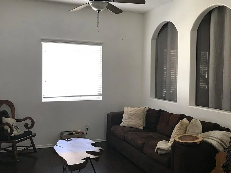Open concept living room space- that opens to small office area behind the archways.
