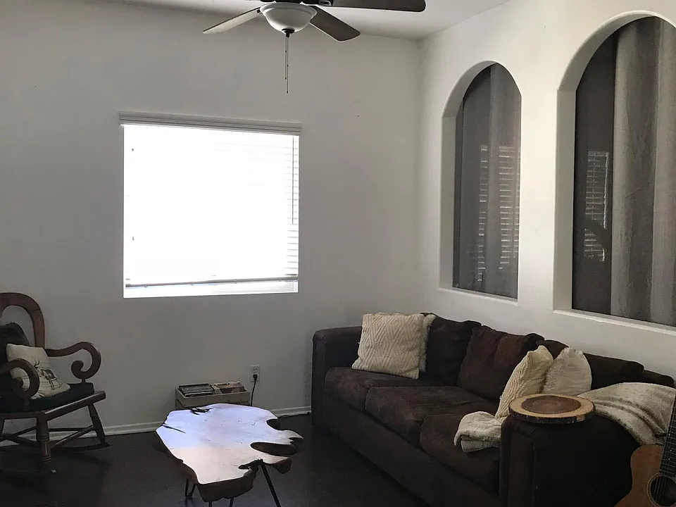 Open concept living room space- that opens to small office area behind the archways.