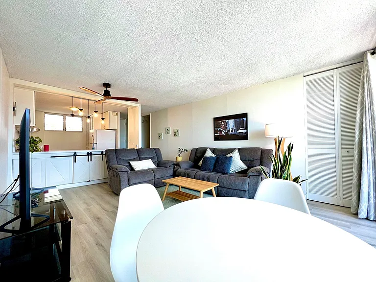 Living Room. 2 Reclining sofas, coffee table, 58" Smart TV w/ stand, ceiling fan, dining table w/ 4 chairs (view from dining area)