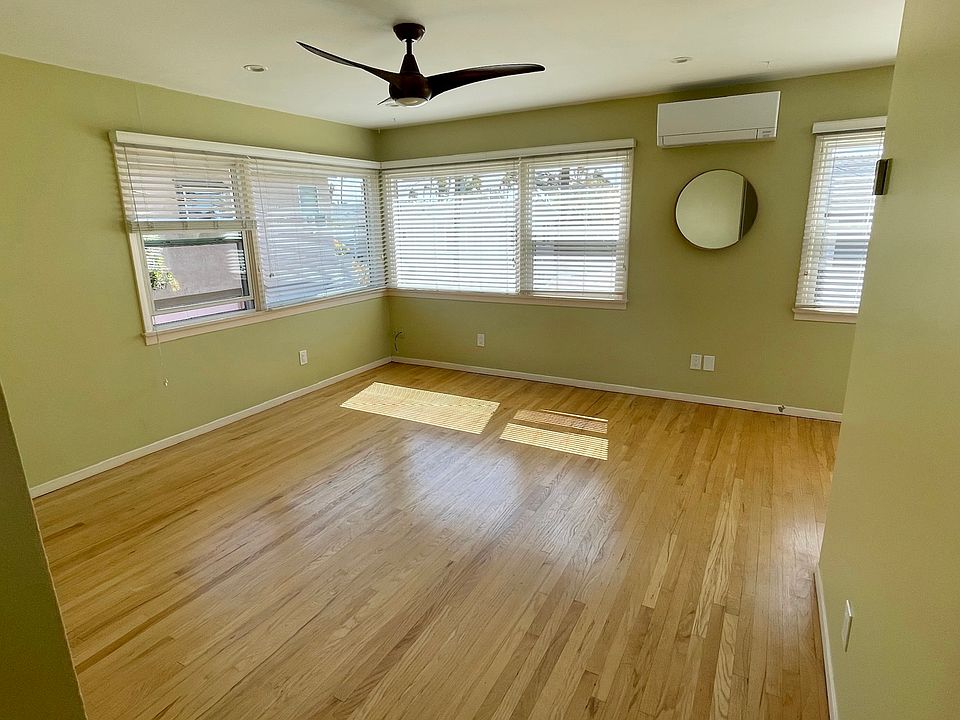 View of Living room from entry hall - light and bright! Room features ceiling fan, recessed lighting, and large picture windows.