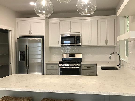 Kitchen featuring stainless steel appliances, quartz countertops and subway tile backsplash.