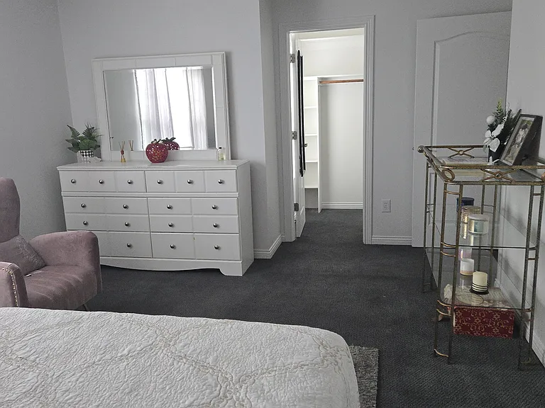 Bedroom 3: Queen bed, dresser, walk-in closet, area rug, remote-controlled ceiling fan, curtains, chair