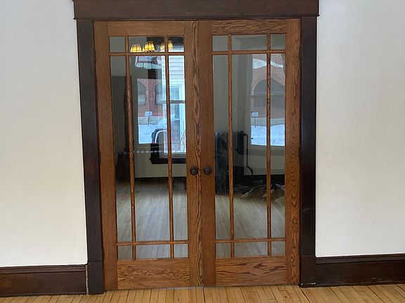 View from dining room into Bedroom 1 through French doors