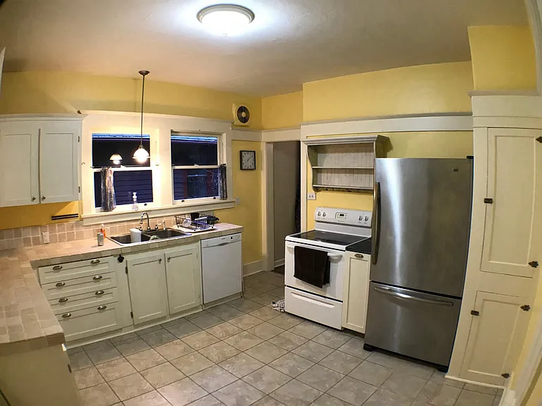 Kitchen has stainless fridge, electric stove, and dishwasher.