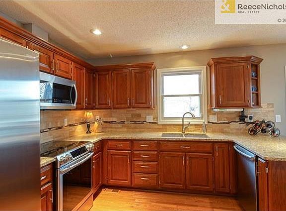 Kitchen, granite counters, tile backsplash, stainless appliances.