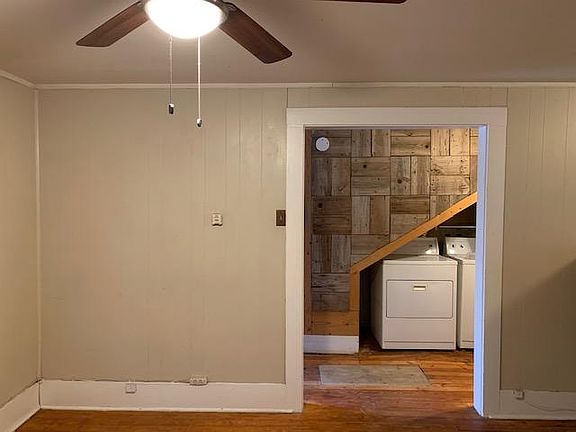 Living room facing entry hall and utility area with washer and dryer connections