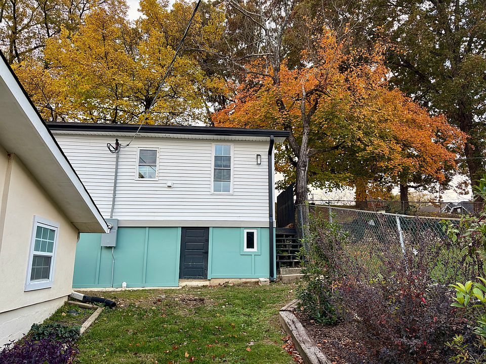Duplex & yard in front, Tremont-facing side of house with crawlspace door & window shown