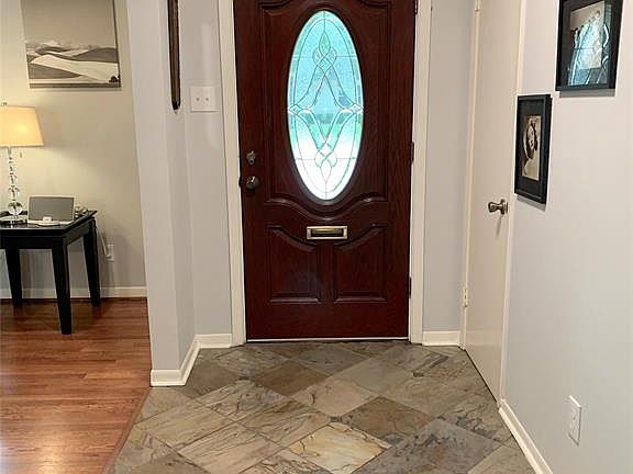 Entry hall with pretty oval beveled glass front door. Slate tiled entry hall with coat closet. Crown molding.