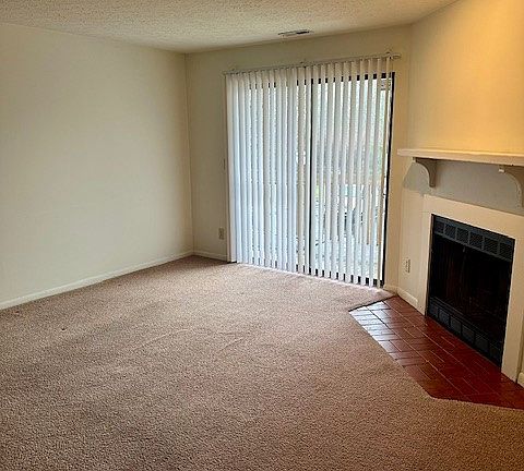 Living room has a wood burning fireplace and sliding glass door to balcony