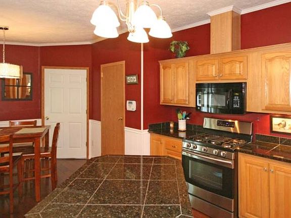 Welcome inside to the beautifully renovated kitchen complete with a granite tile island and new stainless gas stove and microwave.  In addition to the countertops are new lighting, smart laminate flooring plus new sink and faucets making this kitchen a hit. To the right is a pantry and also an entrance to the 10x10 den/office.  The laundry is located conveniently at the far left and also included are the front loading washer and dryer! An added bonus is the city water that was recently installed and a new furnace and hot water heater installed in 2013.