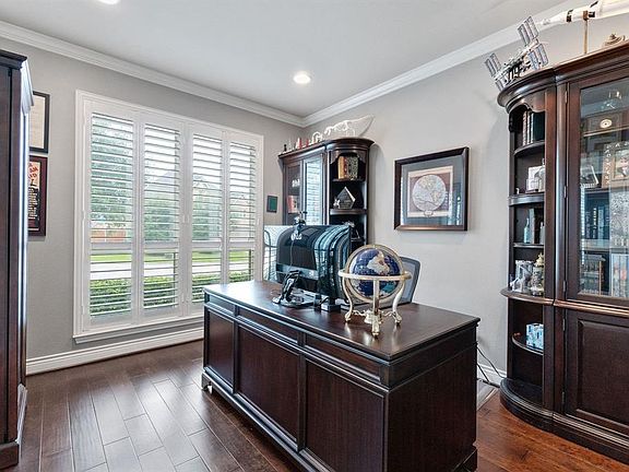 Notice the plantation shutters, crown molding and wood floors